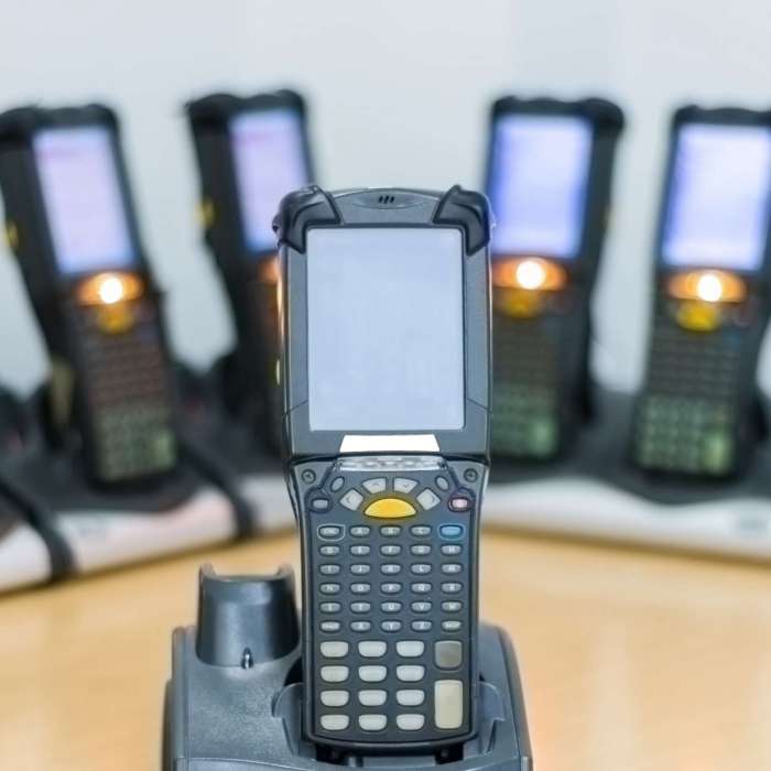bluetooth barcode scanners are charging on the table. use for the work in the warehouse and logistics line. the technology works in a systematic and modern.